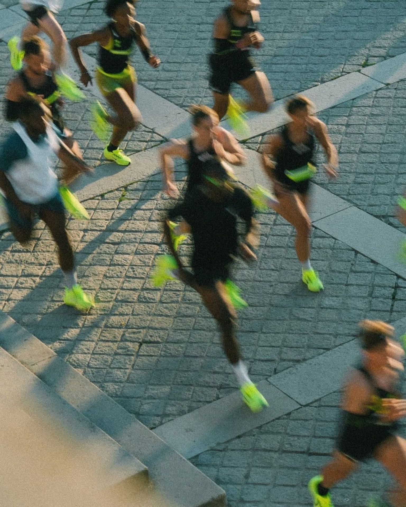 Run-Crew von oben beim Laufen über Kopfsteinpflaster